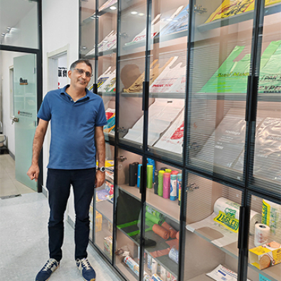 Customers visit the company and take photos next to the product display cabinet.