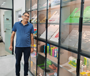 Customers visit the company and take photos next to the product display cabinet.