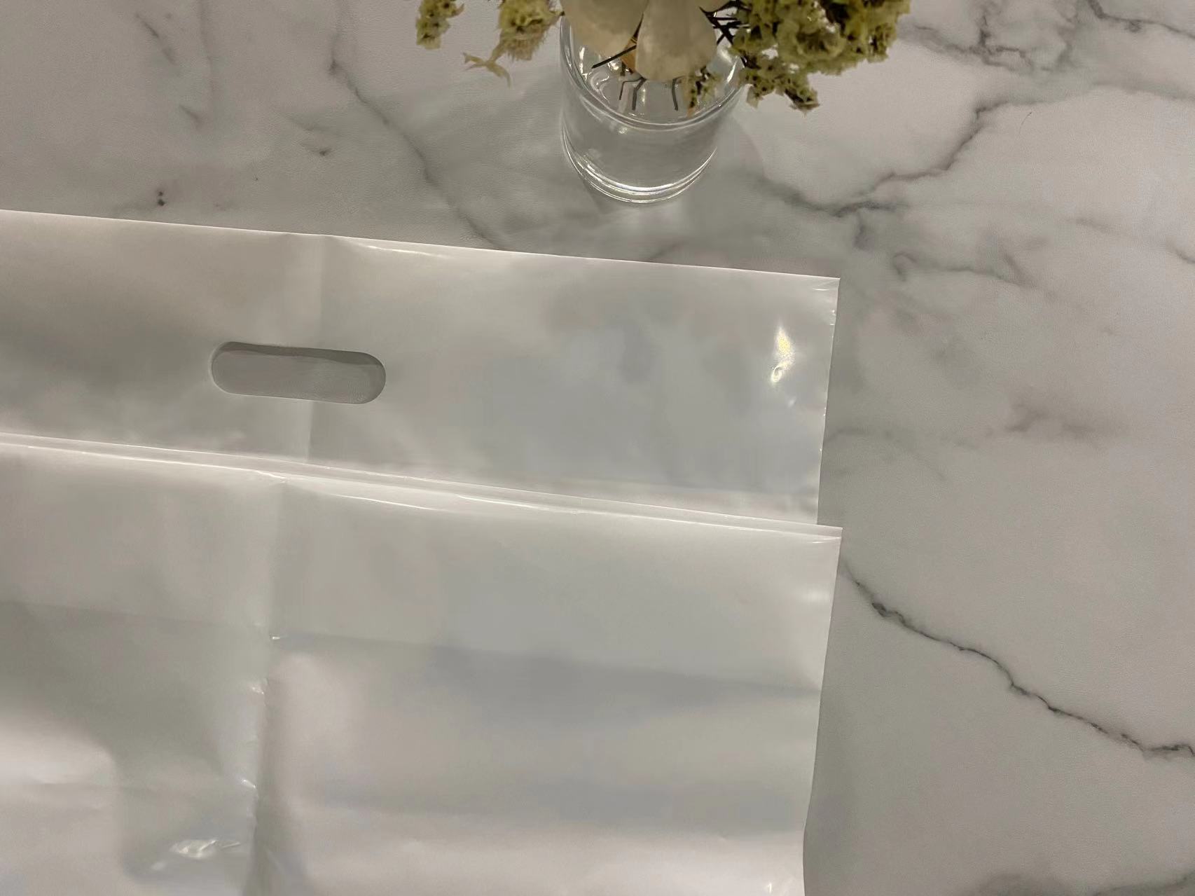 أكياس بمقبض مقطوع من LDPE باللون الأبيض بدون طباعة أكياس بمقبض مقطوع من LDPE باللون الأبيض بدون طباعة